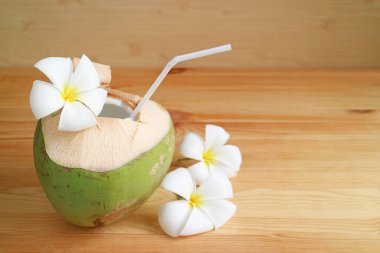 Tahta masaya izole edilmiş hindistan cevizi kabuklu taze hindistan cevizi suyu.