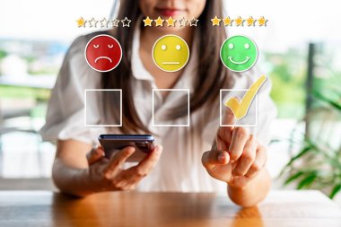 Genç bayan gezgin, sosyal medyada restorandaki yiyecek ve içeceklerin beş yıldızlı memnuniyet derecesini vermek için akıllı telefon kullanıyor. Seyahat yaşam tarzı kavramı.