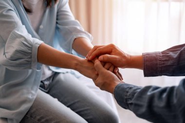 Evinde başı ciddi belada olan üzgün bir kadını teselli eden ve destekleyen genç bir adam.