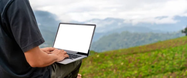 stock image Young man freelancer traveler working online using laptop and enjoying the beautiful nature landscape with mountain view