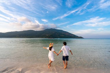 Genç çift gezgin dalgalı, şeffaf deniz, yaz tatili ve seyahat konseptiyle tropikal beyaz kumsalda dinleniyor ve eğleniyor.