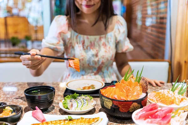 日本料理店で刺身を食べる若いアジア人女性 — ストック写真
