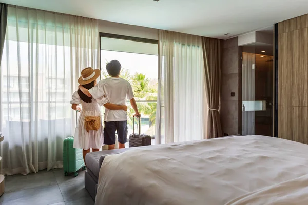 Young Couple Traveler Opening Curtains Looking View Window Hotel Room — Stock Photo, Image