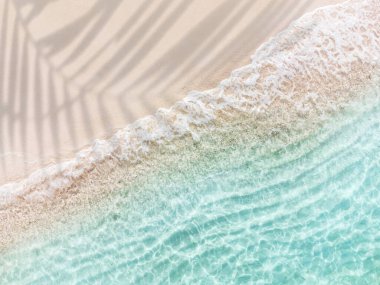 Dalgalı ve şeffaf deniz, yaz tatili ve fotokopi alanı ile seyahat arka planı olan güzel tropikal beyaz kumsal manzarası.