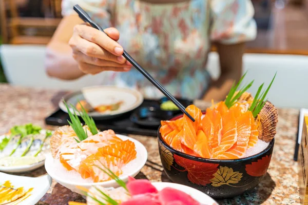 日本料理店で刺身を食べる若いアジア人女性 — ストック写真