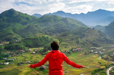 Genç gezgin ayakta duruyor ve Sapa, Vietnam 'daki yeşil pirinç teraslarına bakıyor.