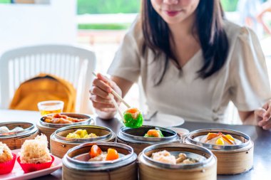 Genç bayan gezgin restoranda geleneksel Çin Dim Sum yiyor.