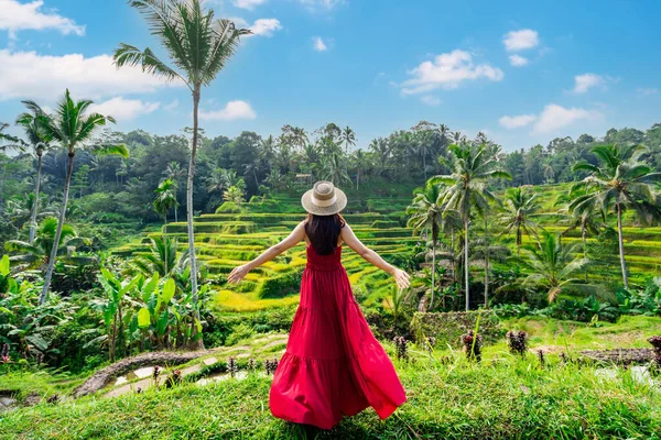stock image Young female tourist in red dress looking at the beautiful tegalalang rice terrace in Bali, Indonesia