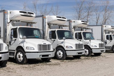 Indianapolis - Circa April 2023: Freightliner Semi Tractor Trailer Big Rig Trucks Lined up for sale. Freightliner is owned by Daimler. clipart