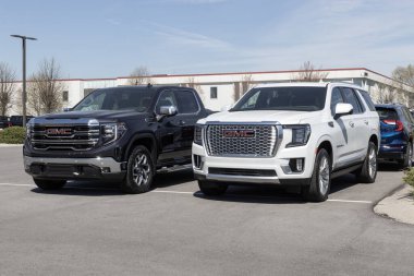 Carmel - Nisan 2023: GMC Yukon ve Sierra 1500 bir galeride sergileniyor. GMC, General Motors 'un lüks SUV, kamyonet ve minibüs bölümü..