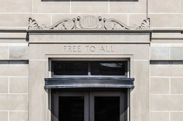 FREE TO ALL text in sandstone library building facade.