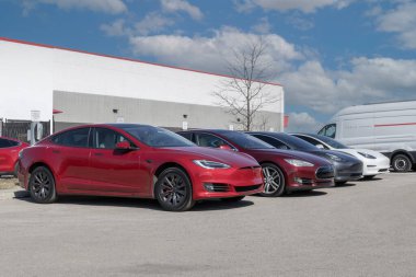 Indianapolis - 25 Şubat 2024: Tesla EV elektrikli araçlar şarj ediliyor. Tesla ürünleri arasında elektrikli arabalar, batarya enerji deposu ve güneş panelleri yer alıyor.