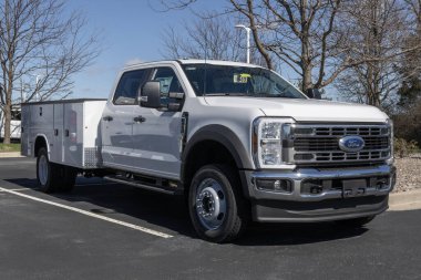 Plainfield - 10 Mart 2024: Ford F-450 4X4 mürettebat taksisi ve bir galeride servis elemanı. Ford F350 'yi benzin ya da dizel motorlarla sunuyor. MY:2024