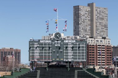 Chicago - April 6, 2024: Wrigley Field center field scoreboard in the bleachers of the Chicago Cubs. Wrigley Field scoreboard is manually operated. clipart