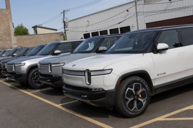 Chicago - May 12, 2024: Rivian R1S SUV and R1T Light Pickup Truck display at the Rivian Service Center. clipart