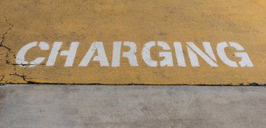 Elektrikli taşıt EV şarj istasyonunun yanındaki betona yükleme metni.