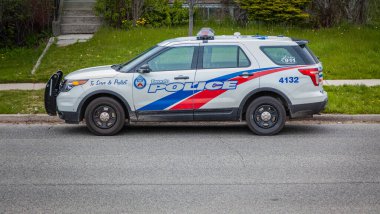 Toronto, Kanada, 17 Mayıs 2020 - Sessiz bir mahallede mavi ve kırmızı çizgili beyaz Toronto polis aracı