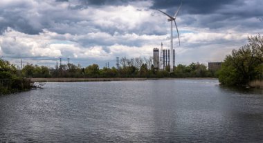  Pickering, Ontario, Kanada 'da bulutlu bir günde yel değirmeni gölü boyunca görüldü.