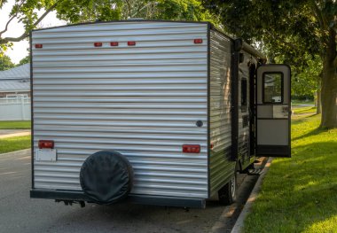 Kamp karavanının arka manzarasında yerleşim yerindeki yolda açık bir kapı var.