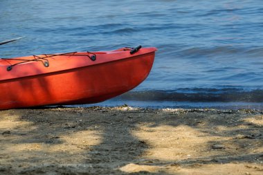 Gölün kıyısındaki kırmızı kano.
