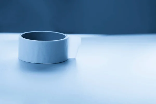 Round roll of white duct tape, adhesive tape on a surface