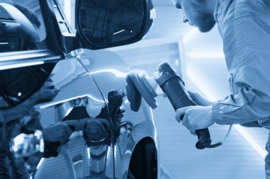 İş aletini tutan el cilası, araba cilası, Oto Tamircisi Araba cilası konsepti.