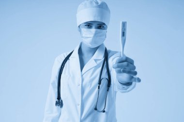 Genç bayan doktor, beyaz arkaplanda fotokopi alanı ile termometre gösteriyor.