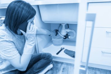 Lavabonun yanında oturan kadın yardım istiyor.