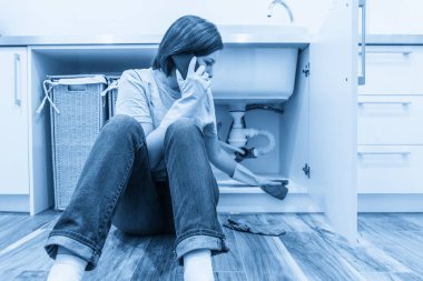 Lavabonun yanında oturan kadın yardım istiyor.