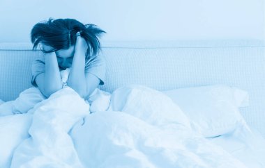 evde, yatakta beyaz keten boşaltmak için metni sola oturan genç esmer kadın