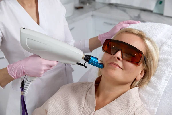Woman receiving laser treatment, beauty concept