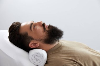 Male patient lying on the couch in a cosmetologist office before procedure