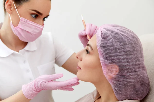 美容师在病人脸上画上记号 准备进行年轻化治疗 — 图库照片