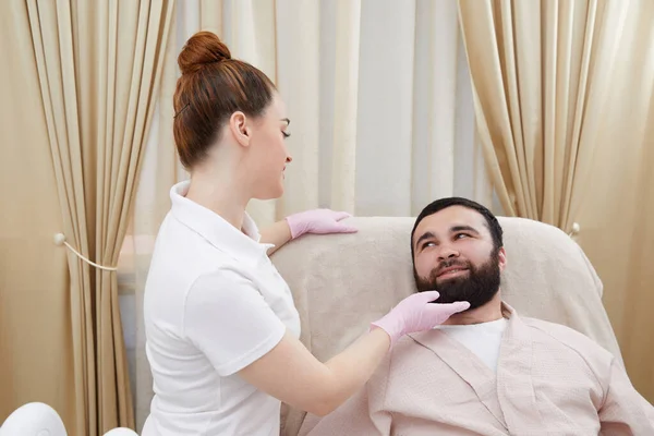 stock image Beautician talking with young man in cosmetology cabinet