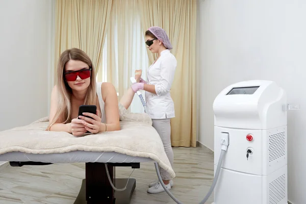 Młoda Kobieta Poddawana Laserowemu Leczeniu Nóg Przedstawiającemu Połączenie Piękna Nowoczesnej — Zdjęcie stockowe
