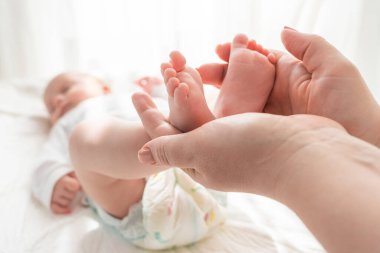 Anneler, yeni doğmuş bebeğinin küçük ayaklarını nazikçe tutarlar. Saf sevgi ve bağlılık gösterirler.