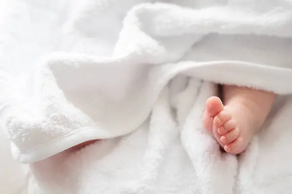 stock image A heart-touching portrayal of pure innocence as a newborn babys foot tenderly peeks out from a soft white towel