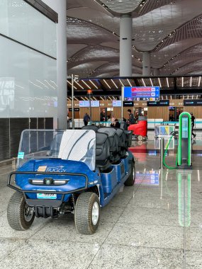 İstanbul, Türkiye - 19 Nisan 2024: İstanbul havalimanında elektrikli araba için elektrikli golf arabası ve şarj istasyonu