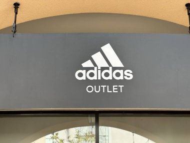 Belgrad, Sırbistan - 16 Haziran 2024: Adidas Outlet mağazasının üç şeritli ünlü logosu ve markasını yakalayan açık hava tabela çekimi