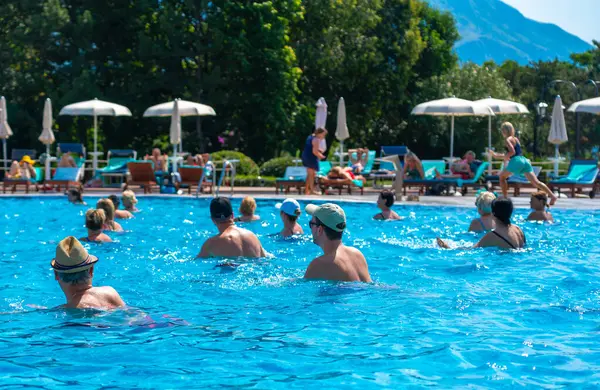 BUDVA, MONTENEGRO - EYLÜL 08, 2023: Açık havuzda bir otellerde su aerobiği yapan grup. Fitness kavramı ve suda eğlence