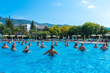 BUDVA, MONTENEGRO - EYLÜL 08, 2023: Açık havuzda bir otellerde su aerobiği yapan grup. Fitness kavramı ve suda eğlence