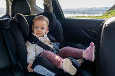 Baby in a car seat enjoying a car ride. Concept of travelling safely with kids clipart