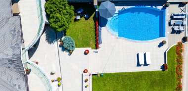 Yüzme havuzu ve terası olan lüks bir villa manzarası.