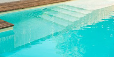 Modern villada temiz mavi suyla yüzme havuzu girişi. Havuza girmek için uygun bir yer. Merdivenli özel yüzme havuzu