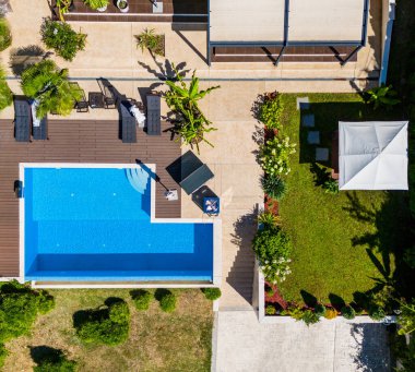 Yüzme havuzu ve terası olan lüks bir villa manzarası.