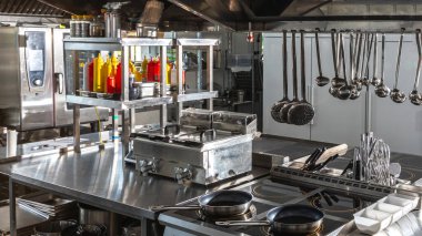 Modern restoran mutfağında gelişmiş aşçılık ekipmanları ve cihazları bulunmaktadır. Kullanıma hazır temiz ve boş mutfağı olan lüks bir mutfak kavramı