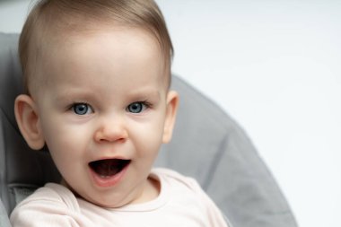 Mavi gözlü bir bebeğin yakın çekimi, esnemenin ortasında kalmış, sakin ve doğal masumiyetini ifade ediyor. Hafif rahatlama, uykusuzluk ve erken çocukluktaki hassas anlar.