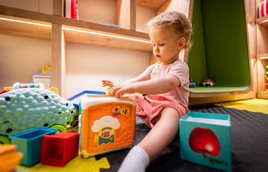 Bebekler renkli blokları ve oyuncakları keşfediyorlar.