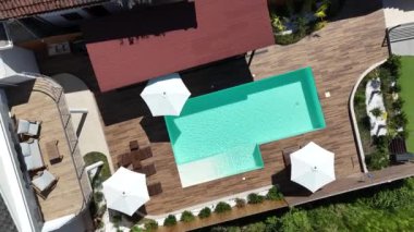 Yüzme havuzu ve terası olan lüks bir villa manzarası.