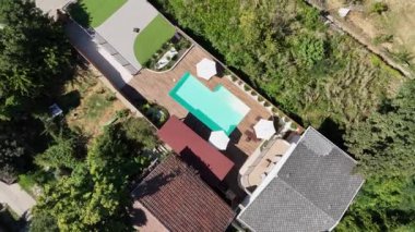Yüzme havuzu ve terası olan lüks bir villa manzarası.